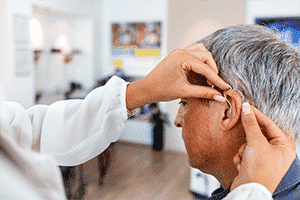 Mature man getting hearing aids fitted